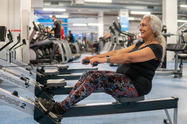 Woman exercising on a rowing machine in the gym